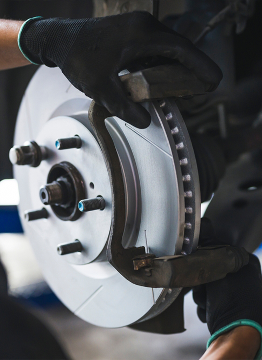 A man holding some parts for car breaks